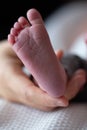 Newborn child`s foot held by a hand Royalty Free Stock Photo