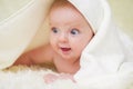 Newborn child relaxing in bed. Six months old baby with a towel after taking a bath, in bed at home Royalty Free Stock Photo