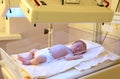 Newborn child under ultraviolet lamps