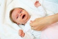 Newborn cries when he is dressed Royalty Free Stock Photo