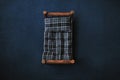 Newborn dark blue backdrop - wooden bed with plaid mattress and pillow on dark blue background with pine cones