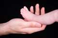 Newborn foot in an adult hand