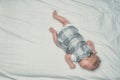 Newborn girl in a dress sleeping lying on her stomach. White sheet. Top view. Place for text Royalty Free Stock Photo