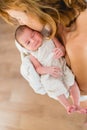 Newborn girl in loving arms of her mother