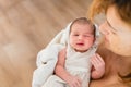 Newborn girl in loving arms of her mother