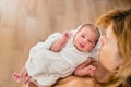 Newborn girl in loving arms of her mother