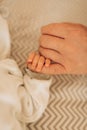 The newborn is holding his father`s finger. Cropped. Link between generations. Mother`s day, father`s day