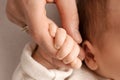 A newborn holds on to mom& x27;s, dad& x27;s finger. Hands of parents and baby close up. A child trusts and holds her tight Royalty Free Stock Photo