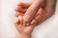 A newborn holds on to mom& x27;s, dad& x27;s finger. Hands of parents and baby close up. A child trusts and holds her tight Royalty Free Stock Photo