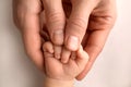 A newborn holds on to mom& x27;s, dad& x27;s finger. Hands of parents and baby close up. A child trusts and holds her tight Royalty Free Stock Photo