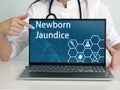 Newborn Jaundice text in list. Doctor looking for something at laptop