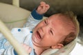 The newborn lies on swing automatic electrical chair and crying