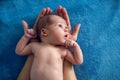 Newborn lies on two arms of his father