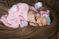 Newborn little girl who sleeps soap, soft pink scarf covered with lace satin flower, in full height Royalty Free Stock Photo