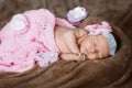 Newborn little girl who sleeps soap, soft pink scarf covered with lace satin flower, gently folded under the handle small head Royalty Free Stock Photo