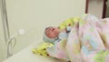 Newborn lying on the swaddling table in the hospital.