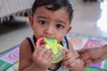 A newborn male teething toddler biting a teether with his gums