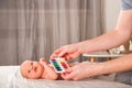 Newborn with paints on a white plaid closeup. Infant holds watercolor rainbow paint and copy space. The concept of the game, care