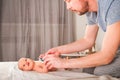 Newborn with paints on a white plaid closeup. Infant holds watercolor rainbow paint and copy space. The concept of the game, care