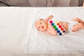 Newborn with paints on a white plaid closeup. Infant holds watercolor rainbow paint and copy space. The concept of the game, care