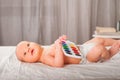 Newborn with paints on a white plaid closeup. Infant holds watercolor rainbow paint and copy space. The concept of the game, care