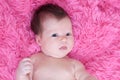 Newborn portrait, baby girl lying on pink background looking Royalty Free Stock Photo