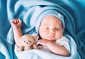 Newborn sleep at first days of life. Portrait of new born baby one week old with cute soft toy in crib in cloth background Royalty Free Stock Photo