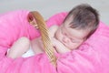 Newborn sleeping. Infant baby girl closeup lying on pink blanket in basket. Cute portrait of child. Royalty Free Stock Photo