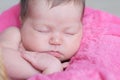 Newborn sleeping. Infant baby girl closeup lying on pink blanket in basket. Cute portrait of child. Royalty Free Stock Photo