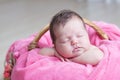 Newborn sleeping. Infant baby girl lying on pink blanket in basket. Cute portrait child. Royalty Free Stock Photo