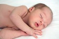 Newborn sleeps on a bed on white background