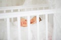 Newborn sleeps in white crib. concept of healthy children`s sleep.