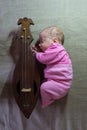 A newborn baby with a folk stringed musical instrument