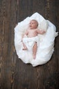 Newborn toddler with blue curious eyes on wooden background