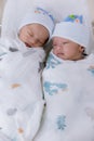 Newborn twins sleeping. Newborn Babies Twins Sleep in Bed. Lovely sleep of the newborns babies on the bed. Royalty Free Stock Photo