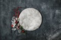 Newborn winter background - round cream bowl with CHristmas red berries and snow covered branches garland on dark backdrop