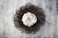 Newborn winter background - rustic natural wreath with white fluffy layer on snow covered backdrop