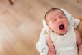 Newborn yawning in her mother`s arms