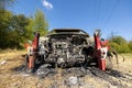 Newburn UK: April 2022: A stolen car which has been burnt out and dumped in a field. Bu rnt engine. Small car Peugeot shape Royalty Free Stock Photo