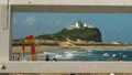 NEWCASTLE, AUSTRALIA- APRIL, 3, 2016 nobbys head in newcastle framed by fence railing