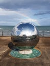 Newcastle, County Down, IRELAND - August 5h, 2019: A large reflective metal steel sphere sculpture on new promenade