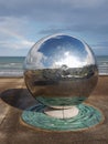 Newcastle, County Down, IRELAND - August 5h, 2019: A large reflective metal steel sphere sculpture on new promenade