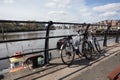 Pair of bikes leaning on a railing by river during a rest stop in the sunshine