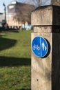 Circular blue shared cycle path sign for cyclists and pedestrians on a wooden post
