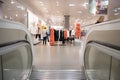 Escalator exit inside a modern department store exiting to ladies fashion clothing department