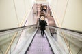 Escalator going down inside a modern department store shop with woman Royalty Free Stock Photo