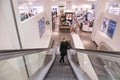 Escalator going down inside a modern department store shop with woman. Royalty Free Stock Photo