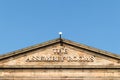 Exterior of The Assembly Rooms building showing sign with blue sky behind