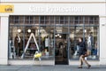 Exterior of Cats Protection charity shop showing logo, sign, signage, branding, window display and entrance with person walking pa Royalty Free Stock Photo