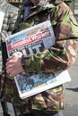 Man in British Army Camoflage Jacket holding a copy of Socialist Worker